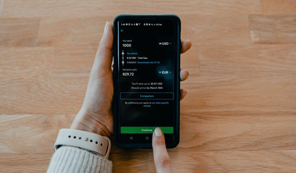 sending money person holding black samsung android smartphone